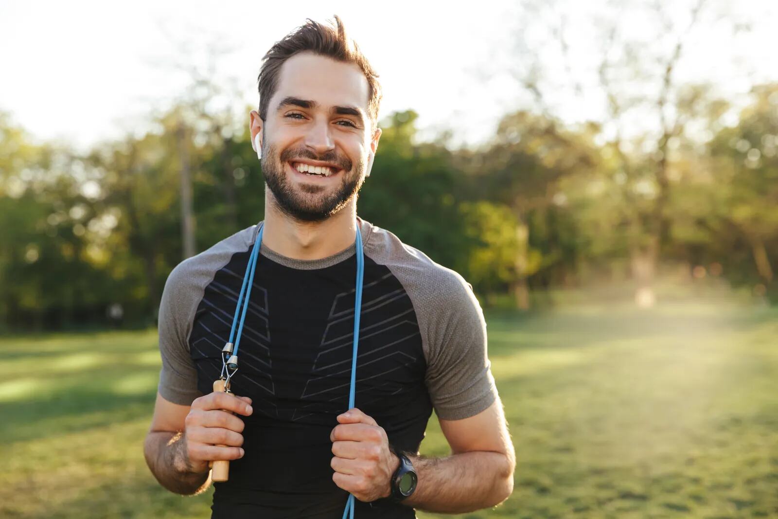 A man smiling outdoors in sportswear