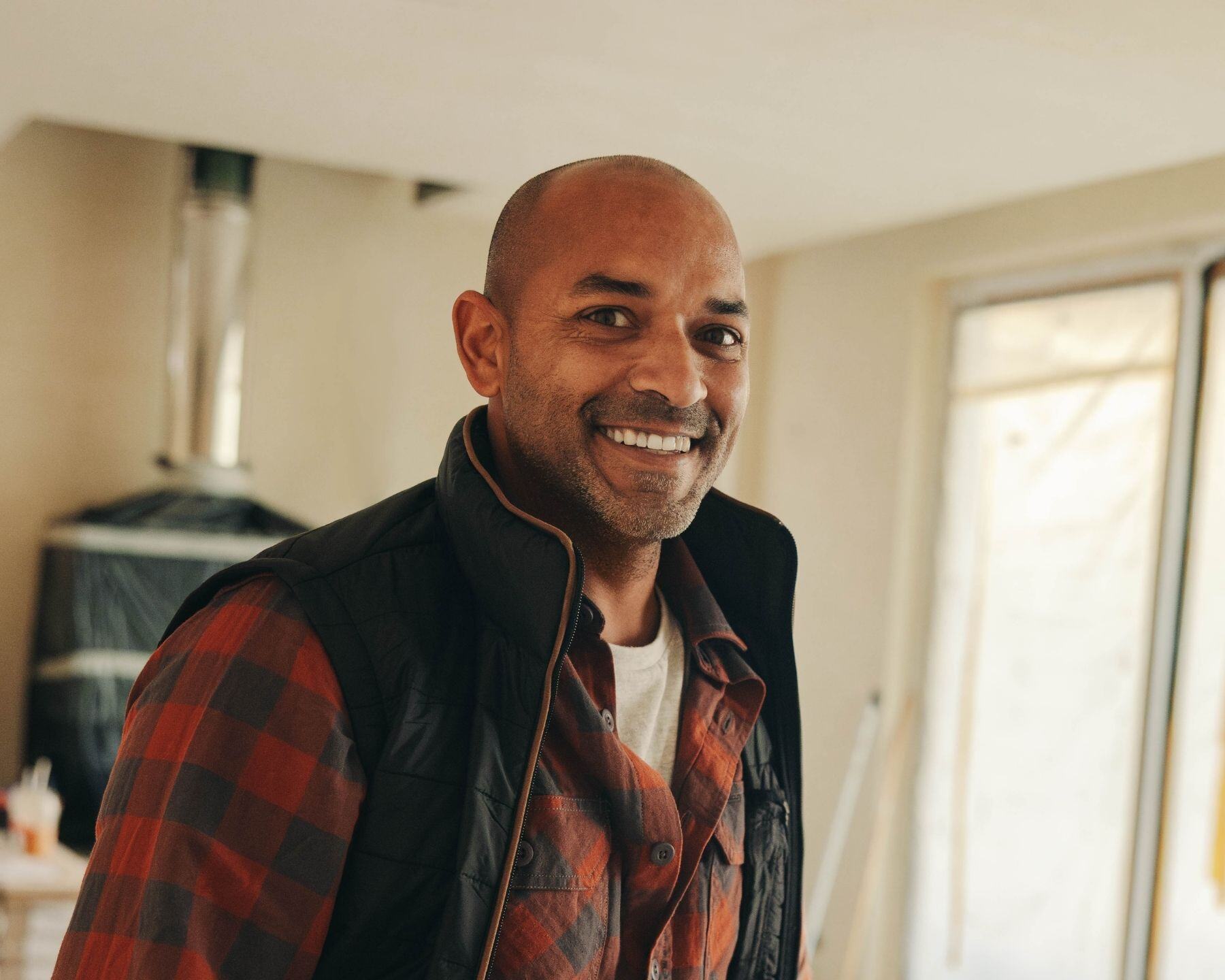 A man smiling at home, his teeth showing