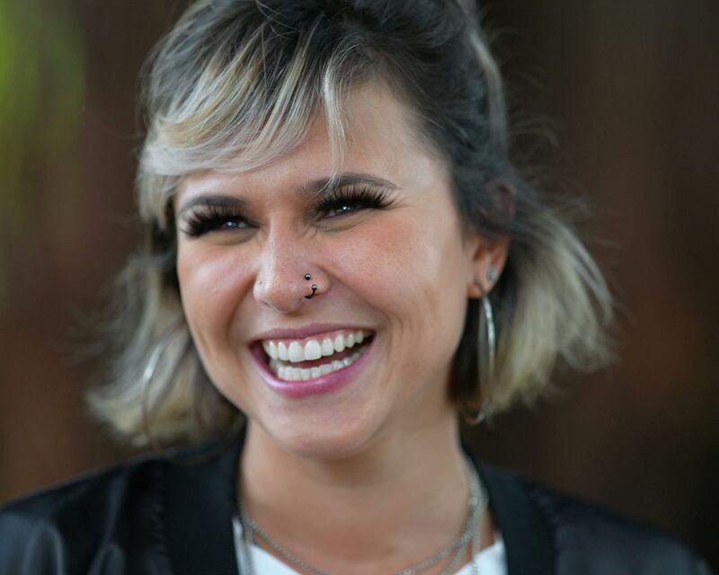 A woman with a blonde bob laughing